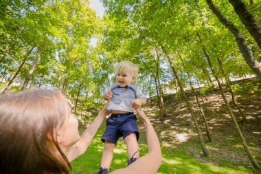 Küçük oğluyla açık oynayan genç mutlu anne.