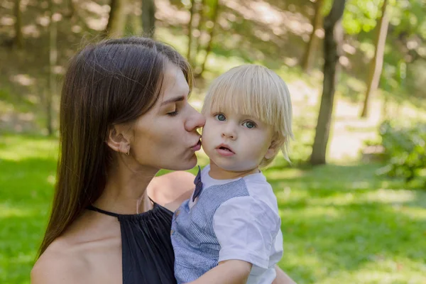 Çok üzgün anne ve küçük oğlu parkta kollarında..
