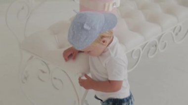 Güzel, mutlu küçük çocuk beyaz odada oynuyor..