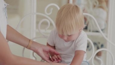 Güzel mutlu anne ve oğul beyaz yatakta oynuyorlar..