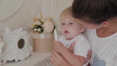 Güzel mutlu anne ve oğul beyaz yatakta oynuyorlar..
