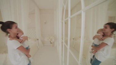 Güzel, mutlu küçük çocuk beyaz odada oynuyor..