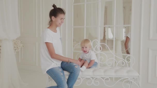 Красива щаслива мама і син грають на білому ліжку . — стокове відео