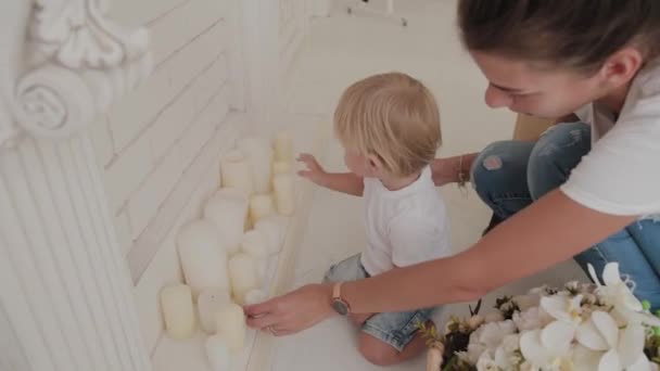 Hermosa madre feliz y el hijo están jugando en la cama blanca . — Vídeos de Stock