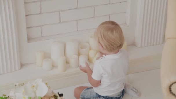 Mooi gelukkig jongetje speelt in de witte kamer. — Stockvideo