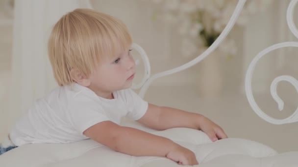 Beautiful happy little boy is playing in the white room. — Stock Video