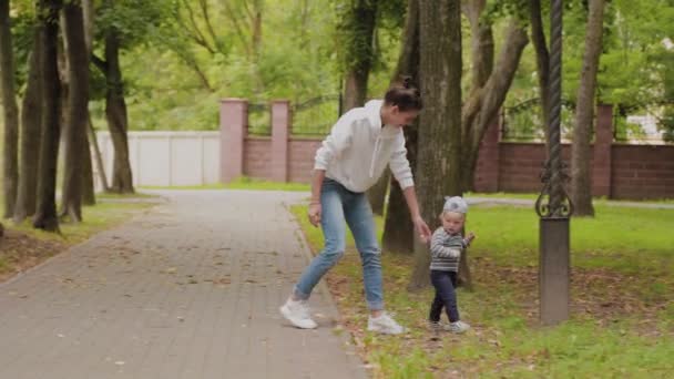 Glückliche Mutter spaziert mit ihrem Sohn im Park. — Stockvideo