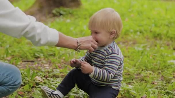 Feliz madre con su hijo juega en la hierba . — Vídeo de stock