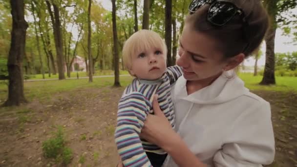 Ευτυχισμένη μαμά περπατά με το γιο της στο πάρκο. — Αρχείο Βίντεο