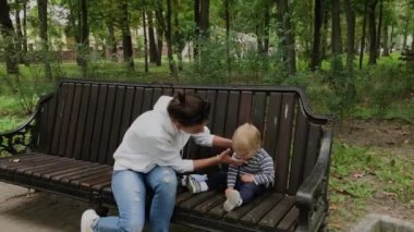 Parktaki bankta oğluyla mutlu bir anne.
