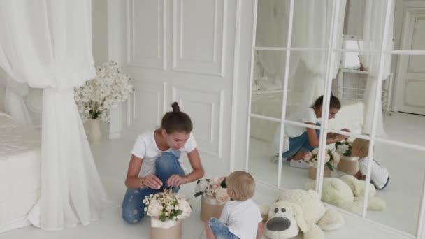 Mooi gelukkig mam en zoon zijn spelen op de wit bed. — Stockvideo