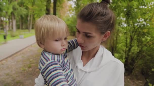 Šťastná maminka chodí se svým synem v parku. — Stock video