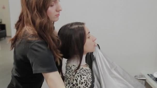Peluquería chica prepara a un cliente para cortes de pelo . — Vídeos de Stock