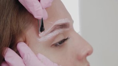 Profesyonel makyöz müşteri kızı için kaş makyajı yapar..