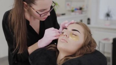 Profesyonel makyöz güzellik salonundaki müşterileri için kaş yoluyor..