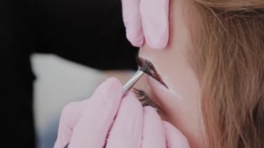 Profesyonel makyöz müşteriye kına ile kaş çizer.