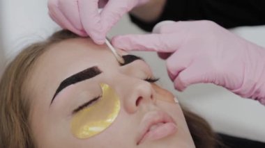 Profesyonel makyöz güzellik salonundaki müşterileri için kaş yoluyor..