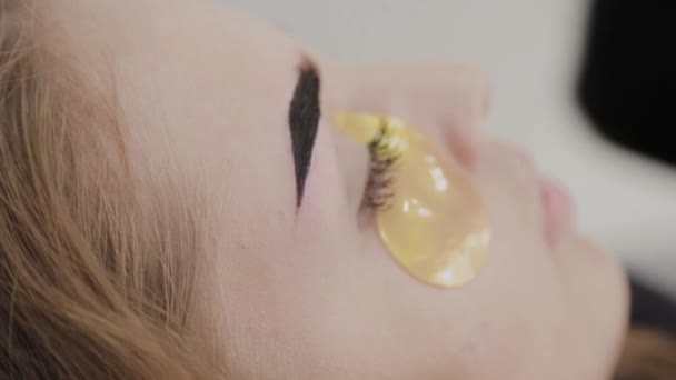 Νεαρή κοπέλα με χρυσή μάσκα κάτω από τα μάτια της. — Αρχείο Βίντεο