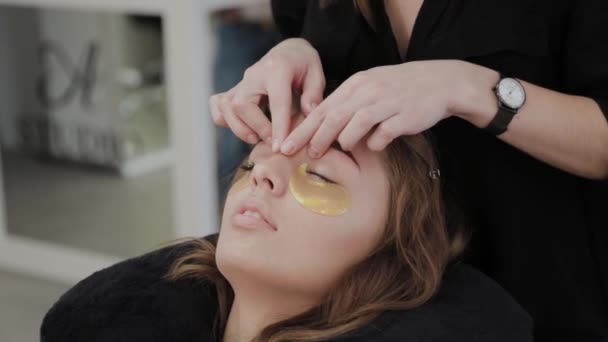 Young girl in a beauty salon doing face massage. — Stock Video