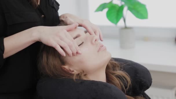 Young girl in a beauty salon doing face massage. — Stock Video