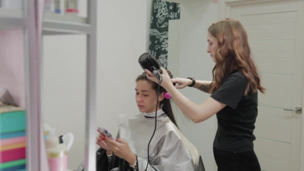 Flicka frisör torkar håret till kund med hårtork på frisör. — Stockvideo