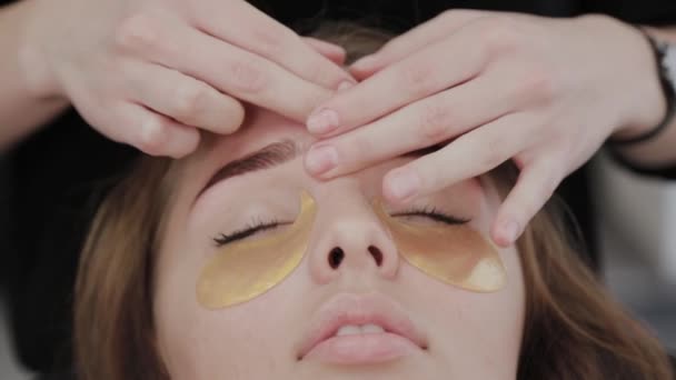 Chica joven en un salón de belleza haciendo masaje facial . — Vídeos de Stock