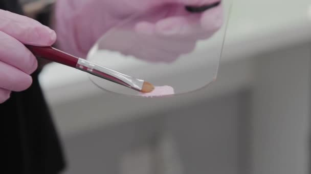 Artista de maquiagem profissional espalha tinta em uma paleta . — Vídeo de Stock