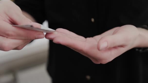 Ragazza truccatore applica crema per massaggi facciali sulle mani . — Video Stock