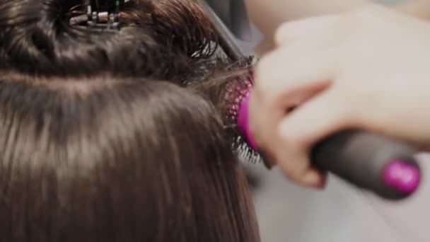 Friseurmädchen trocknet dem Kunden beim Friseur mit Haartrockner die Haare. — Stockvideo