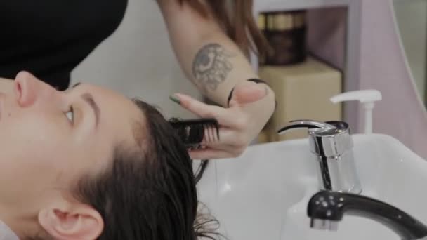 Krásná mladá dívka umýt své vlasy v kadeřnictví. — Stock video