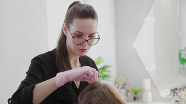 Artista de maquillaje profesional elimina la pintura de cejas al cliente . — Vídeo de stock