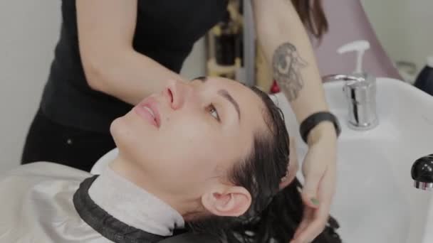 Menina bonita lavar o cabelo no cabeleireiro . — Vídeo de Stock