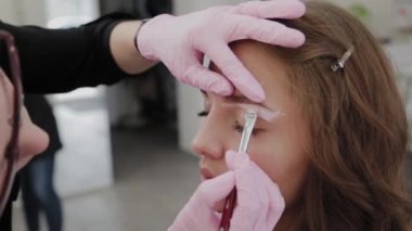 Profesyonel makyöz müşteri kızı için kaş makyajı yapar..