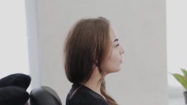 Profesyonel makyöz sandalyeyi açar ve müşteriyi prosedür için yatırır..