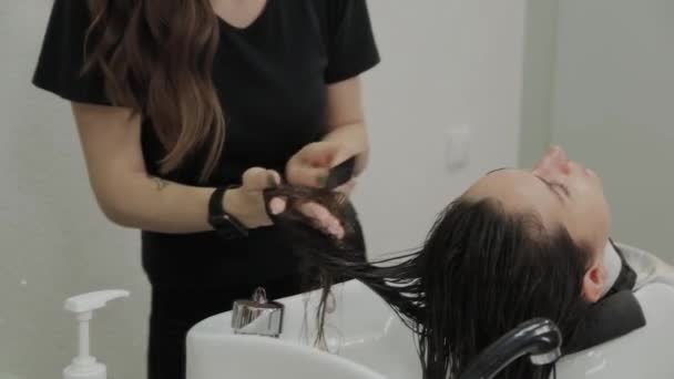 Gadis muda yang cantik mencuci rambut mereka di penata rambut . — Stok Video