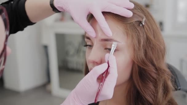Professionelle Make-up-Artist tut Augenbrauen-Markup für Client-Mädchen. — Stockvideo