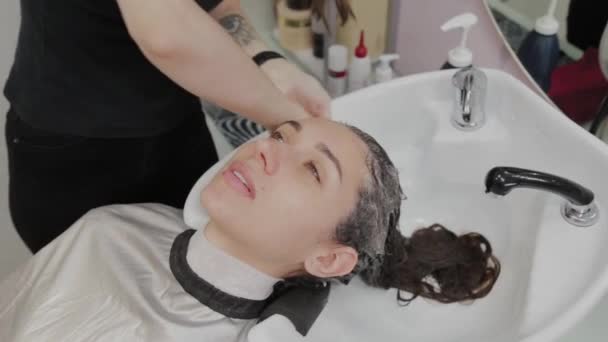 Coiffeuse met shampooing sur la tête d'un client . — Video