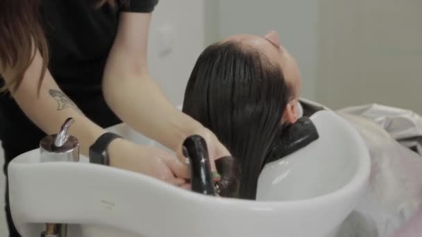Belle jeune fille laver leurs cheveux au salon de coiffure . — Video