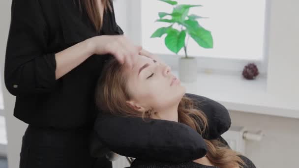 Jong meisje in een schoonheid salon doen gezicht massage. — Stockvideo