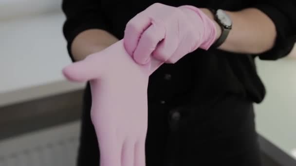 Girl makeup artist puts on rubber gloves before the procedure. — Stock Video