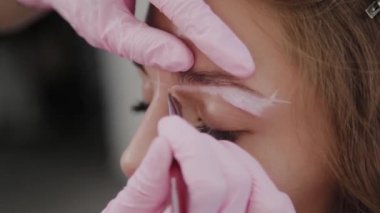 Profesyonel makyöz müşteri kızı için kaş makyajı yapar..