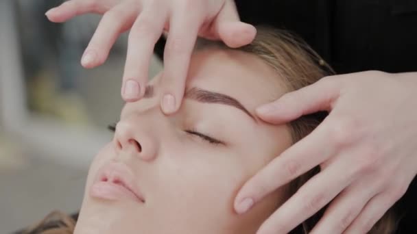 Jong meisje in een schoonheid salon doen gezicht massage. — Stockvideo