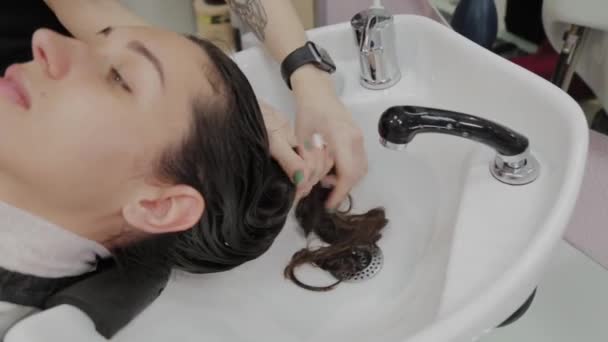Gyönyörű fiatal lány mossa a haját a fodrásznál.. — Stock videók