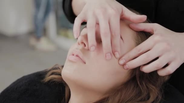 Młoda dziewczyna w salonie piękności robi masaż twarzy. — Wideo stockowe