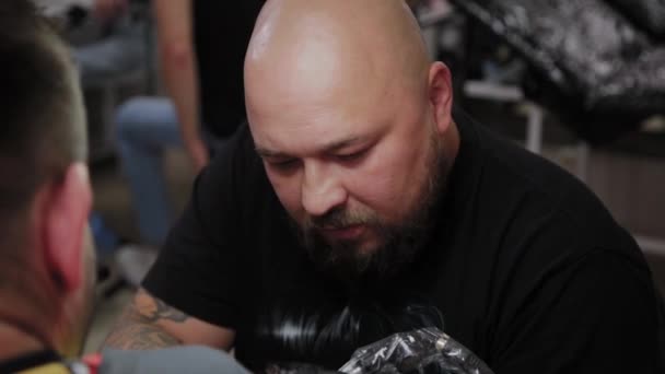 Artista profesional del tatuaje hace un tatuaje en el brazo de un hombre . — Vídeos de Stock