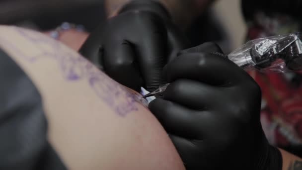 전문 문신가는 사람의 팔에 문신을 한다. — 비디오