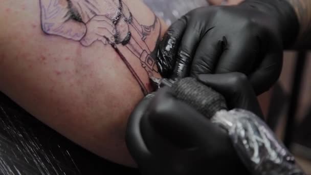 Професійний художник татуювання робить татуювання на руці чоловіка . — стокове відео