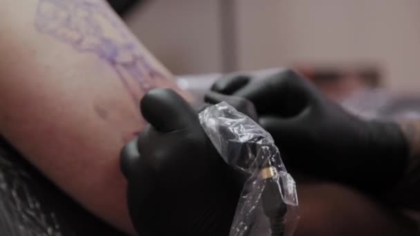 Professionell tatuerare gör en tatuering på en mans arm. — Stockvideo