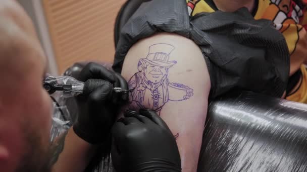 Il tatuatore professionista fa un tatuaggio sul braccio di un uomo . — Video Stock