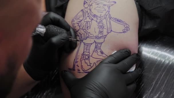 Artista profesional del tatuaje hace un tatuaje en el brazo de un hombre . — Vídeo de stock